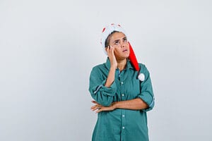Female travel nurse thinking with hand on temple while on Christmas assignments