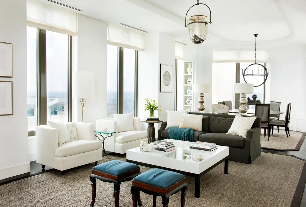 A bright furnished living room with sofas, a coffee table and tall windows